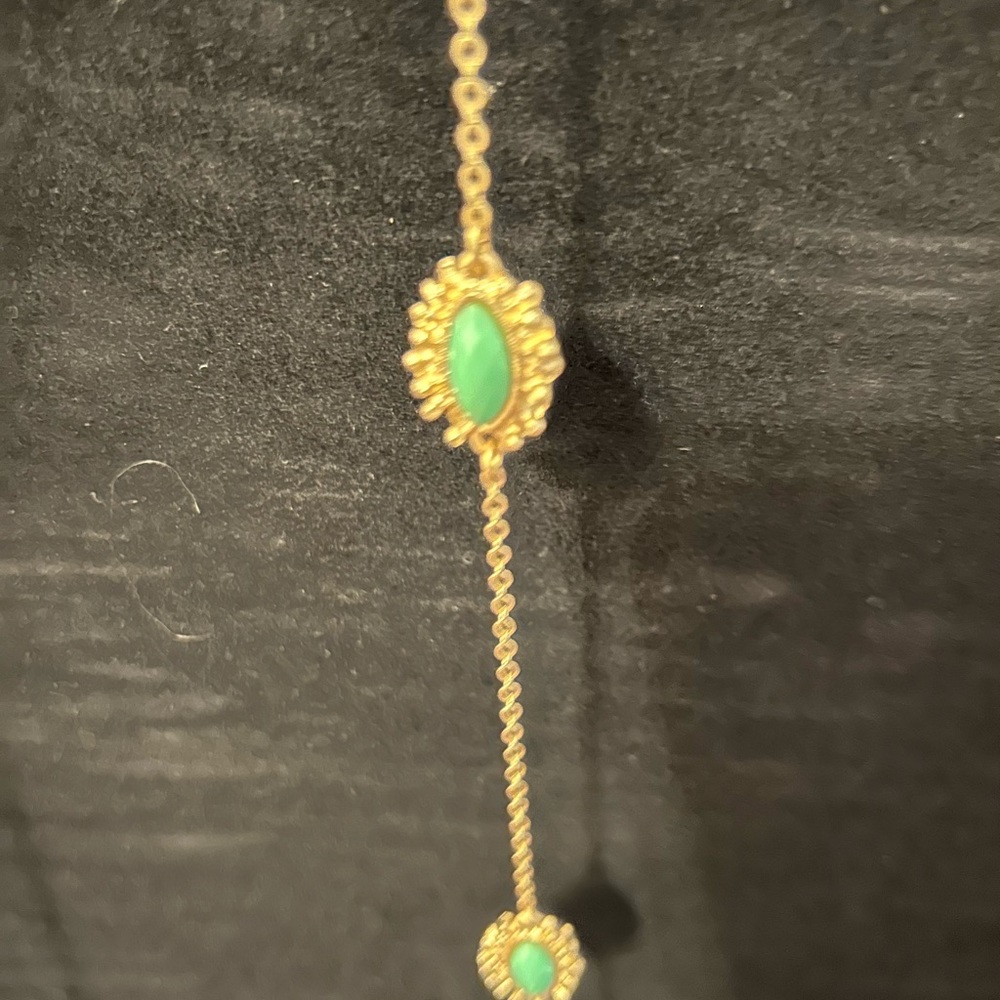 Green colored beads on gold colored chain